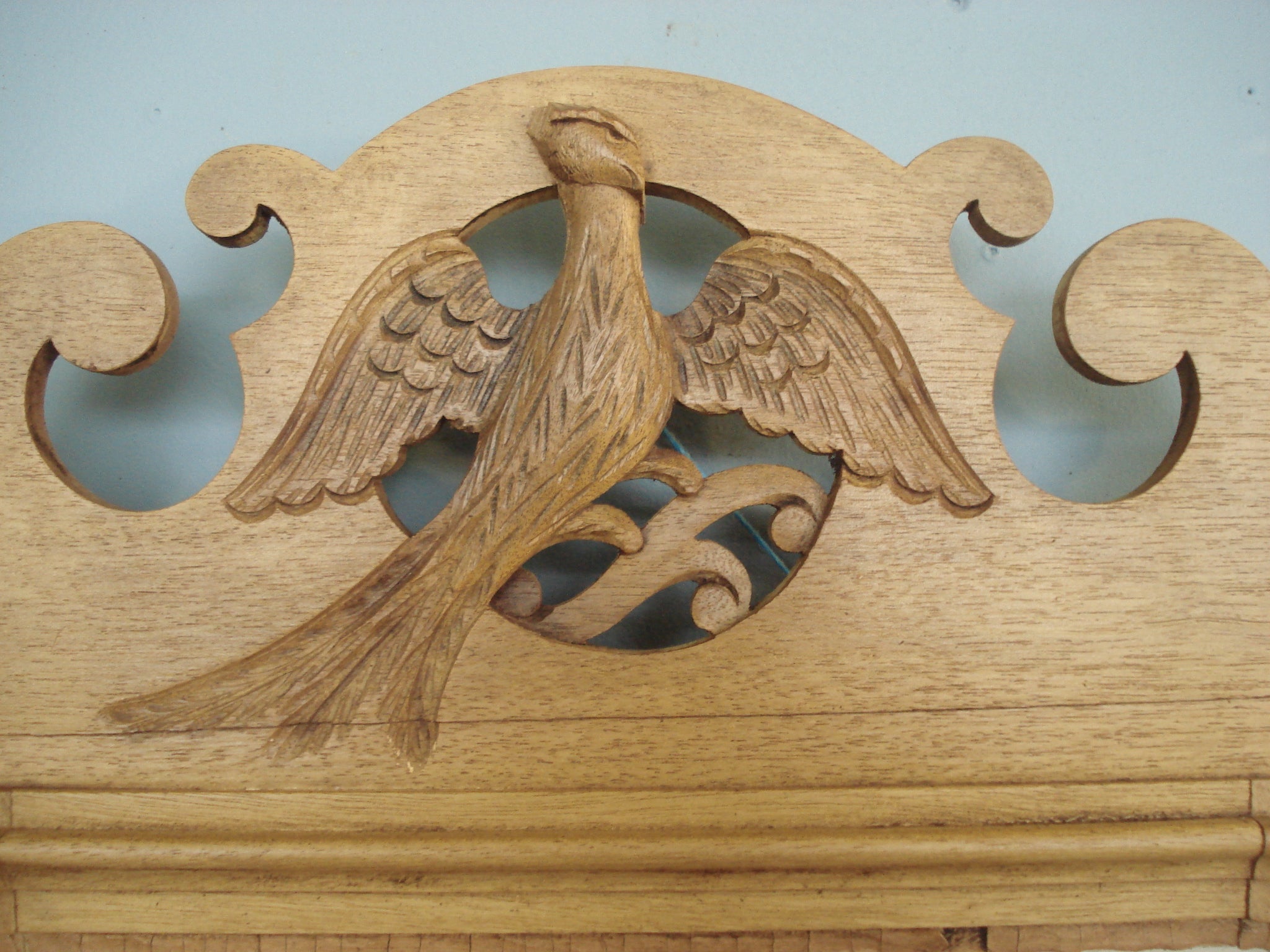 Bevelled mirror in 19th century fretwork frame depicting carved pheasant in flight.